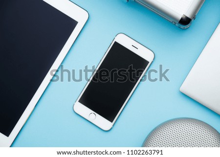 Overhead of office table with laptop, tablet pc, cellphone, speaker and bag. copy space blue flat lays