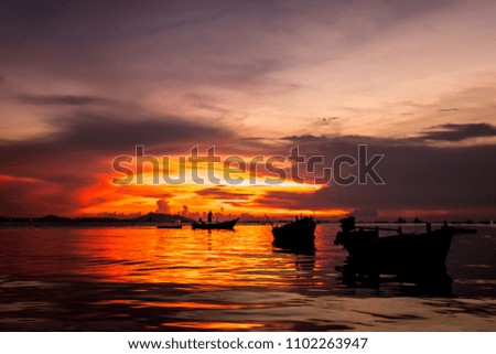 Fisherman on the boat in the sea in silhouette sunset background