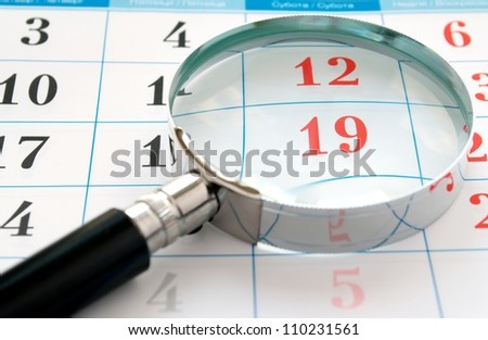 magnifying glass and a calendar to find the right time