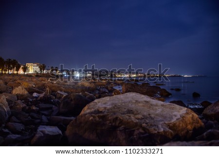 Panorama of the rocky beach of Civitavecchia in Italy with the background of the city shot at night.