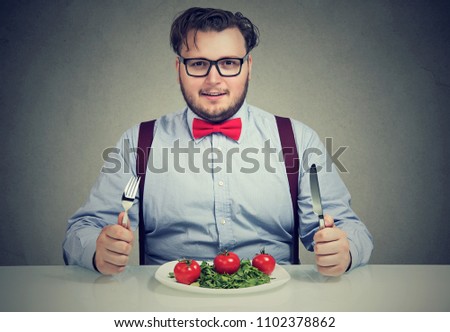 Young overweight man eating healthy food and losing weight looking confidently at camera Royalty-Free Stock Photo #1102378862