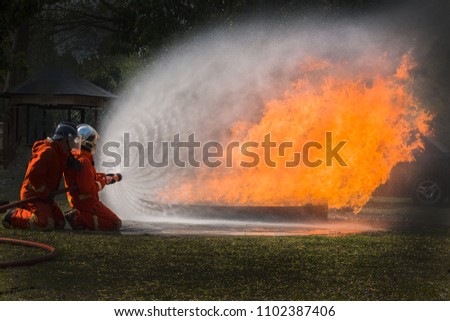 Firefighters in situations, Firefighters training, Team practice to fighting with fire in emergency situation. Spray water to the flame
