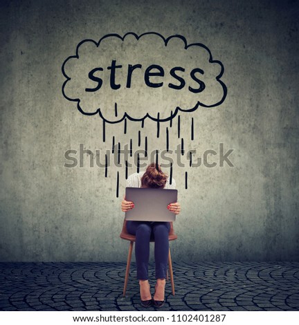 Stressed business woman sitting on chair with laptop computer looking down feeling depressed 