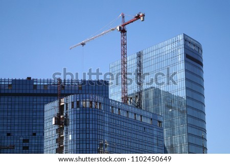 New technologies in the construction of high-rise buildings. Crane and multi-storey tower. City view Blue photo
