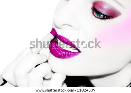 desaturated image with color enhanced on lips and eyes .... woman applying lipstick