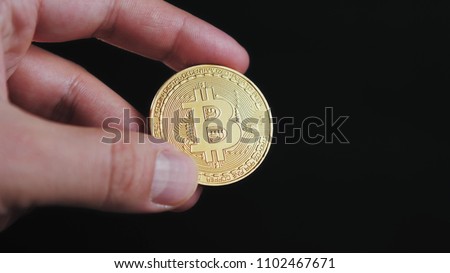 Cryptocurrency golden bitcoin coin. Man holding in hand symbol of crypto currency - electronic virtual money for web banking and international network payment litecoin ethereum neo