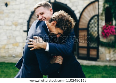 Crazy groom and groomsmen have fun posing on the backyard outside Royalty-Free Stock Photo #1102480163