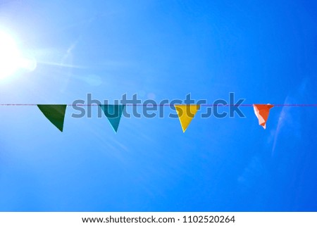 Multicolored triangular paper festival flags on blue sky background. Outdoor Celebration Party. Festive mood