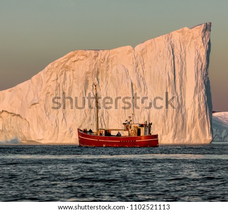 Greenland, Disko Bay. Tourists take pictures of the iceberg. Source of icebergs is by the Jakobshavn glacier. This is a consequence of the phenomenon of global warming and catastrophic thawing of ice