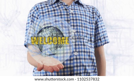 Young man shows a hologram of the planet Earth and text Welcome. Boy with future technology 3d projection on a modern white digital background
