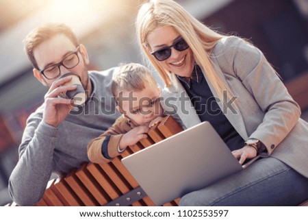 Cheerful young family watching something on laptop.