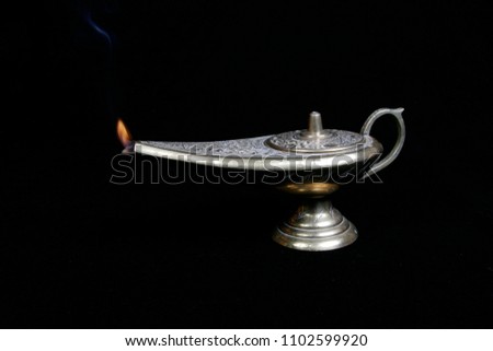 A beautiful detailed metal lamp with a small flame 