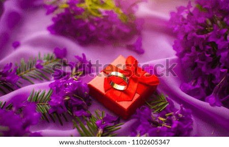 Gift box and bouquet of flowers on wooden table