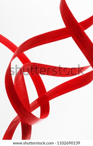 Abstract view of red rolled ribbon isolated on white background.