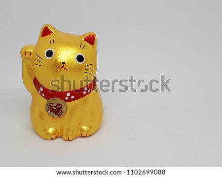 Gold color Japanese lucky cat,Maneki Neko.Isolated on white background.Copy space.Japanese word means fortune.Beckoning hand invites good luck & prosperity.Greeting for business success concept. 