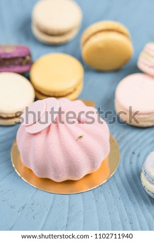 Pink mousse-cake. French macaroon dessert and flowers eucalyptus on a turquoise background. pastel colors