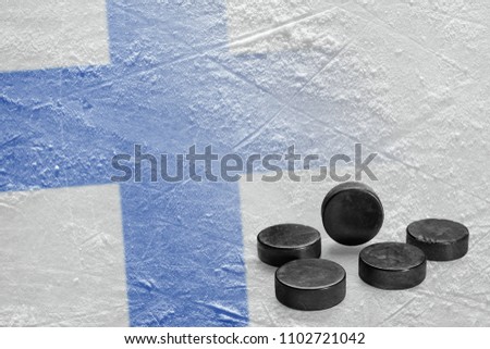 Image of the Finnish flag on ice and hockey pucks. Concept, hockey, background