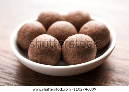 Nachni laddu or Ragi laddoo or balls made using  finger millet, sugar and ghee. It's a healthy food from India. Served in a bowl or plate over moody background. Selective focus
