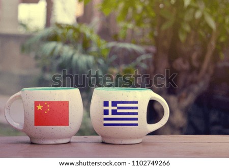 China and Greece Flag on two tea cups with blurry background