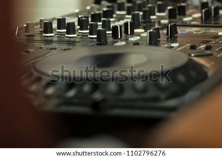dj musical mixer professional console black color with many buttons and knobs in night club or studio, horizontal picture