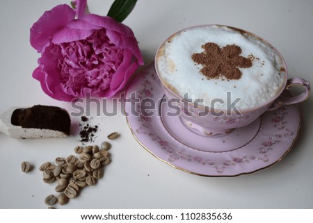 A cup of coffee and peonies on a white background.