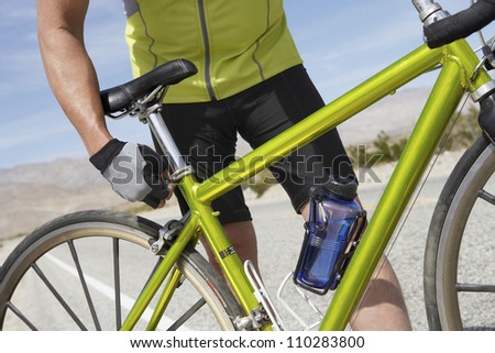 Part of senior man adjusting bicycle seat Royalty-Free Stock Photo #110283800