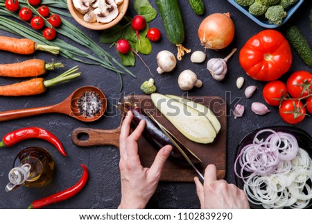 Photo on top of fresh vegetables, champignons, cutting board, oil, knife, eggplant, chef's hands
