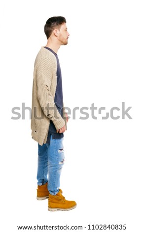 Side view of a stylish man in a knitted sweater. Rear view people collection.  backside view of person.  Isolated over white background. The bored guy put his hands in his pockets