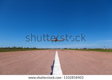The plane low flies over the runway. A small private airfield with different planes. Private aviation Royalty-Free Stock Photo #1102858403