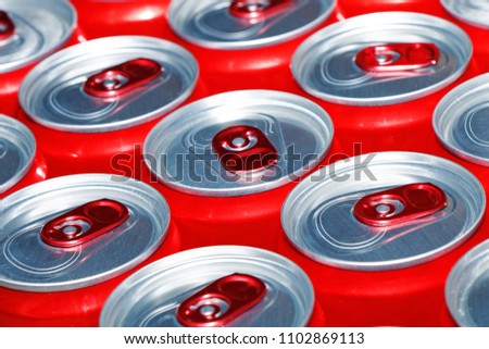 Red cans with a carbonated drink on a white background. View from above