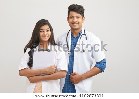 Indian young male and female doctor with note pad 