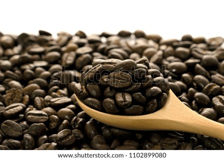 Pictures of coffee beans in a wooden spoon Pile of coffee beans,white background.