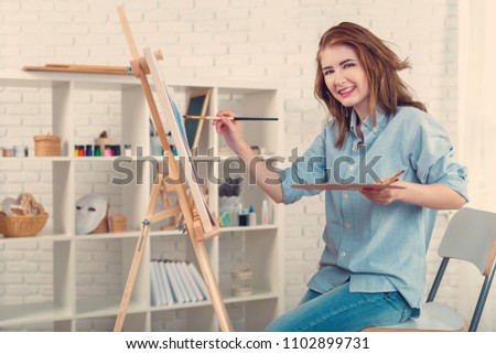 Beautiful young woman painter at work