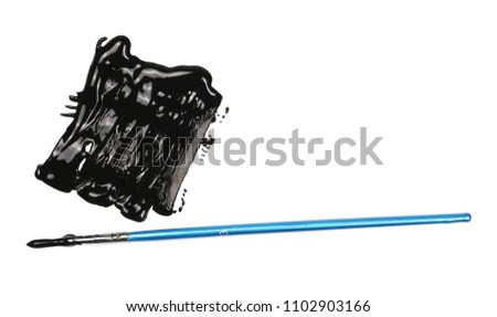 Spilled black watercolor puddle, stains and blue paintbrush isolated on white background, top view