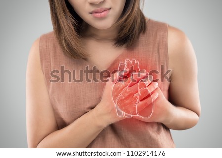 The photo of heart is on the woman's body, Severe heartache, Having heart attack or Painful cramps, Heart disease, Pressing on chest with painful expression. Royalty-Free Stock Photo #1102914176