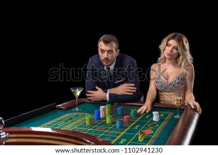 Couple gambling at roulette table in casino