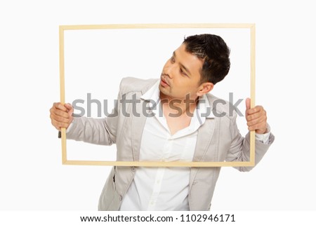 Man trying to go through a wooden picture frame, looking to the right