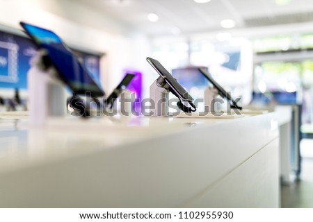 Close up of cell phones or mobile phones on display in a modern, clean and contemporary shop or mall in the UK