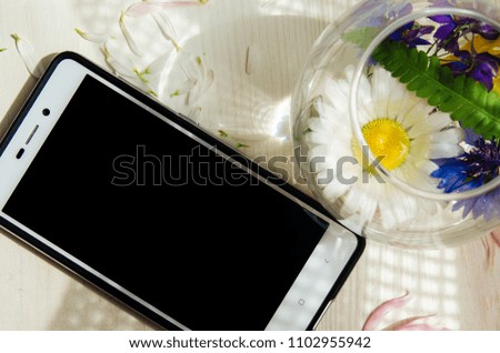 On the white table are the objects. the theme of the summer . gadget , phone is on the table, the sea shells . background on a theme vacation
