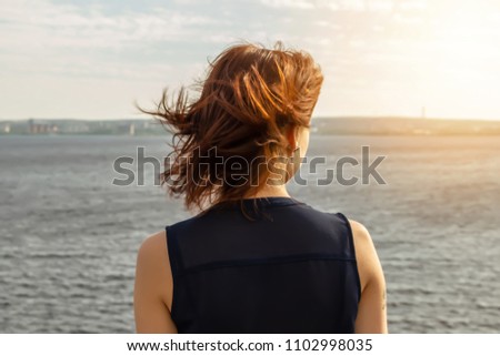 Young girl on the background of the sea with glare from the sun