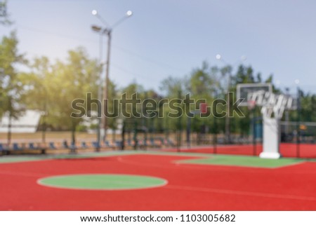 Outodor colorful basketball court in the city park. Blurred background.