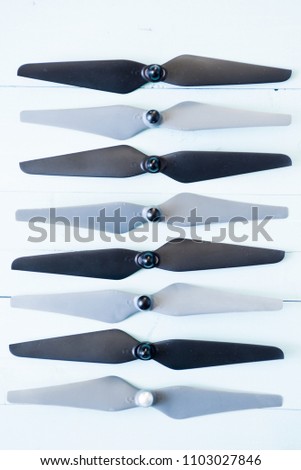 Top view of drone's  propellers, video link, digital transmitter and screwdriver    on a rusty blue background wooden table