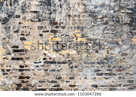 Old rough cracked wall constructed of gray bricks with concrete mortar, mold and peeled paint spots. Horizontal image suitable for interior design, backdrop, wallpaper. Template background.  Royalty-Free Stock Photo #1103047286