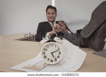 Closeup clock display work time out with businessman relax soft background(selective focus)