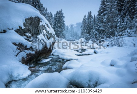 Winter landscape river flowing towards bridge. Royalty-Free Stock Photo #1103096429