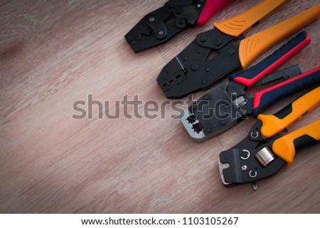 Professional crimper in wooden background. Man hobby style. Electric wok materials. Male design connection. 