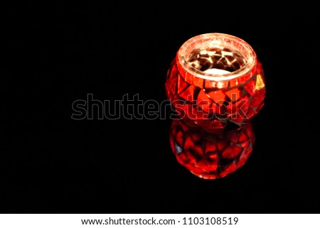 Red candlestick stock images. Decorative candlestick on a black background. Illumination decorative element in the interior