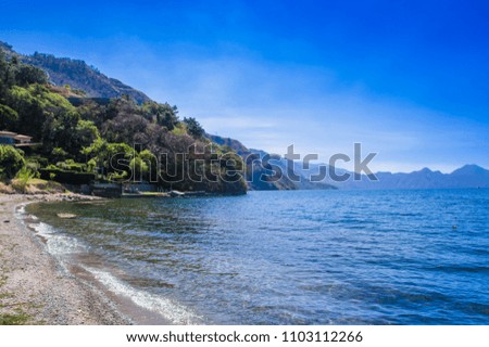 Beautiful outdoor view of shore at Lake Atitlan, during a gorgeous sunny day and blue water in Guatemala