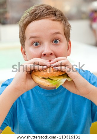 boy in cafe eating hamburger