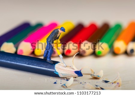 miniature People, pencil, Toys Kids, Figure Workers pressing the pencil Royalty-Free Stock Photo #1103177213